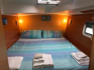 Una cama en una habitación pequeña con toallas. en Catamarano Miragua - Resort on board in Catania, en Catania