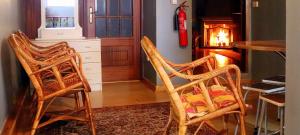 cocina con 2 sillas y chimenea en Alojamento Estrela Peles, en Sabugueiro