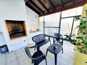 two chairs and a table in a room with a fireplace at Milfontes Guest House - Duna Parque Group in Vila Nova de Milfontes