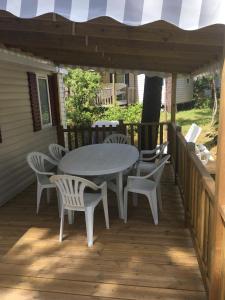 a patio with a table and chairs on a deck at Mobil Home La Palmyre Camping Bonne Anse 4 étoiles in Les Mathes