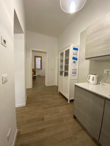 uma cozinha com armários brancos e piso em madeira em Ca' Lucia Apartment em Veneza