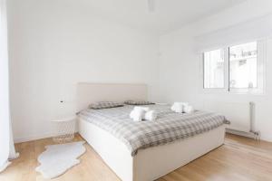 Luxury 2 bedroom 2 bathroom flat in Kolonaki ! في أثينا: غرفة نوم بيضاء مع سرير كبير مع وسائد