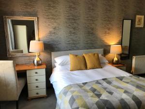 a bedroom with a bed and a desk and a mirror at Rooms @ Number Six in Oakham