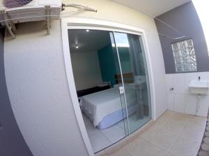 a small room with a bed and a bathroom at Florianópolis Pousada Moçambeach in Florianópolis