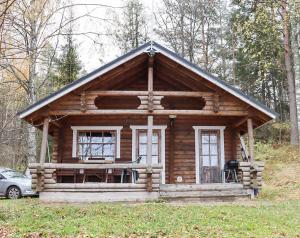 uma cabana de madeira com um alpendre e duas janelas em Rantamökki Onni em Hämeenlinna