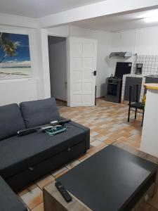 a living room with a couch and a kitchen at Appartement de la Baie in Le Vauclin