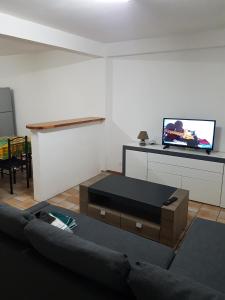 a living room with a couch and a flat screen tv at Appartement de la Baie in Le Vauclin