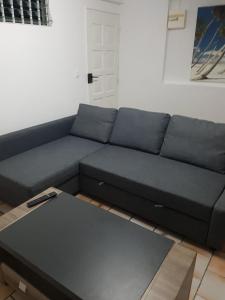 a living room with a blue couch and a coffee table at Appartement de la Baie in Le Vauclin