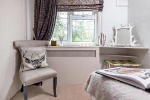 a bedroom with a chair and a window at Crazy Fox Hurley Boutique B&B in Marlow