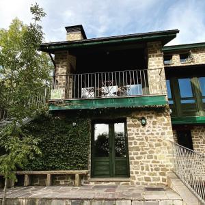 une maison avec un balcon et une porte dans l'établissement Apartamento ático-dúplex en Casa Rural Fundanal en Hoz de Jaca, à Hoz de Jaca