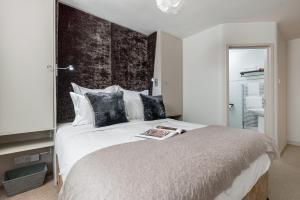 a bedroom with a large bed with a book on it at Crazy Fox Hurley Boutique B&B in Marlow
