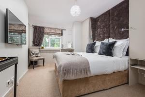 a bedroom with a large bed with a large headboard at Crazy Fox Hurley Boutique B&B in Marlow