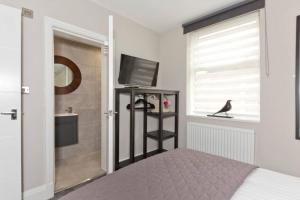 a bedroom with a bed and a television and a window at Blackbird Luxury 2 Bed Accommodation Room 7 in Blackpool
