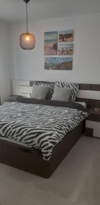 ein schwarzes und weißes Bett in einem weißen Schlafzimmer in der Unterkunft San Javier Sanuk Erjo new built apartment 2 bedrooms ground floor in Santiago de la Ribera + 60 Fotos