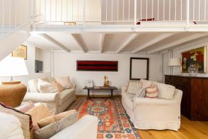 a living room with two white couches and a rug at Charming Studio near Piazza Castello by Wonderful Italy in Turin