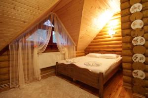 ヤブルニツァにあるЕко котедж Яблуницька трояндаの木造家屋内のベッドルーム(ベッド付)
