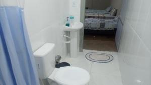 Łazienka z białą toaletą i umywalką w obiekcie Pousada Nascentes da Canastra w mieście São João Batista do Glória