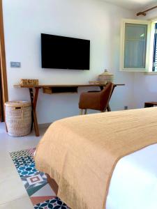 ein Schlafzimmer mit einem Bett und einem TV an der Wand in der Unterkunft BOMA LifeStyle Hotel in Dakar