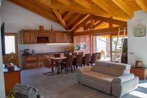 a kitchen and dining room with a table and a couch at Sole Agriturismo in Locatello