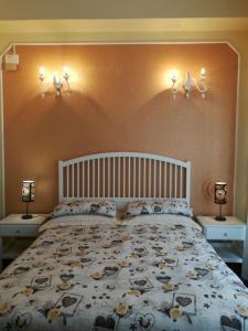 sypialnia z dużym łóżkiem z dwoma światłami na ścianie w obiekcie B&B COLOSSEO w mieście Cosenza