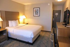 a hotel room with a bed and a flat screen tv at Baymont by Wyndham Effingham in Effingham