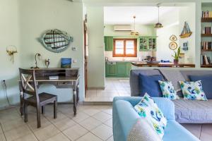 a living room with a blue couch and a table at Villa Peparethos in Stafylos