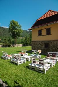 a group of lounge chairs on the grass in front of a building at VILLA GHERMAN in Sălciua de Jos