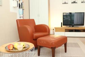 a living room with a chair and a bowl of fruit on a table at Riesling - helle und großzügige Wohnung mit guter Anbindung in Mainz