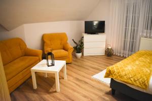a living room with a couch and a chair and a tv at Privát Harenčár in Stará Lesná