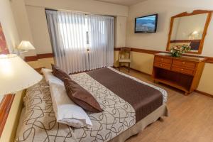 a bedroom with a bed and a dresser and a mirror at Aguas Del Sur in San Carlos de Bariloche