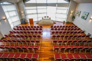 un auditorio vacío con sillas rojas y un escenario en Patagonia Sur Hotel en San Carlos de Bariloche