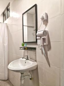 a bathroom with a sink and a mirror and a hair dryer at My Cool Home x The Quintet @ Cameron Highlands in Tanah Rata +96 photos