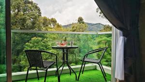 a table and two chairs in front of a large window at My Cool Home x The Quintet @ Cameron Highlands in Tanah Rata