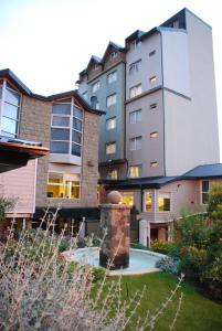 un grand immeuble avec une fontaine dans une cour dans l'établissement Patagonia Sur Hotel, à San Carlos de Bariloche