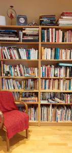 una estantería llena de libros en La Chouette Maison - Chambres d'hôtes et Gîte en Ville en Remiremont