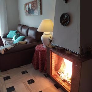 a living room with a fireplace and a couch at Casa escarpes de Trejo in Setenil