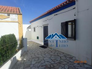 un bâtiment blanc avec un panneau sur son côté dans l'établissement Cantinho do Ilho, à Sesimbra