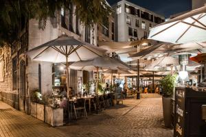 a row of tables and umbrellas on a street at night at Lastarria Aparts in Santiago