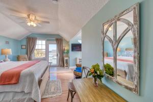 a bedroom with a bed and a mirror and a table at Beachcomber Penthouse in St. Augustine