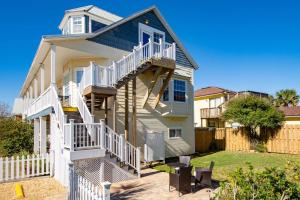 a house with white stairs and a fence at Beachcomber Penthouse in St. Augustine