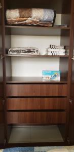 einem Schrank mit Holzregalen und einer Schachtel darauf in der Unterkunft Departamento Equipetrol Ejecutivo Familiar in Santa Cruz de la Sierra