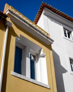 a white and blue building with a window at Alfama Yellow House in Lisbon