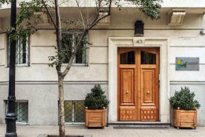 un edificio con una porta in legno e due piante di Lastarria Hotel & Aparts a Santiago