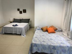 two beds sitting next to each other in a room at Casa edícula no centro com Smart TV in Joinville