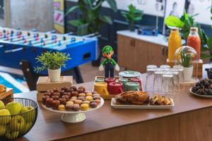 a table topped with plates of food and fruit at Moxy Paris La Villette in Paris