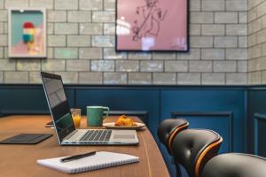 a laptop computer sitting on a table with a plate of food at Moxy Paris La Villette in Paris +39 photos