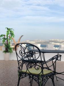 a black table and chair with a view of the ocean at El Muniria in Tangier
