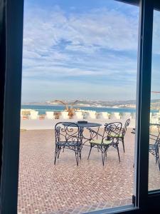 a table and chairs with a view of the ocean at El Muniria in Tangier