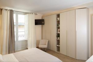 a bedroom with a bed and a chair and a window at Le Terrazze del Teatro Greco in Taormina