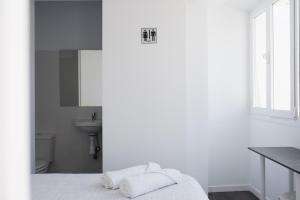 ein weißes Schlafzimmer mit einem Bett und einem Waschbecken in der Unterkunft AYZ Frailes - Auto check-in property in Málaga